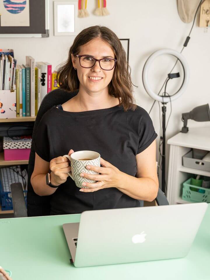 Elm LEaf Studio designer Kirsty McGill sitting at laptop with coffee